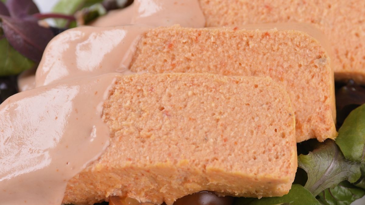 Pastel de cabracho tradicional cortado en porciones, elaborado con leche evaporada para conseguir una textura esponjosa y servido con salsa rosa y ensalada.