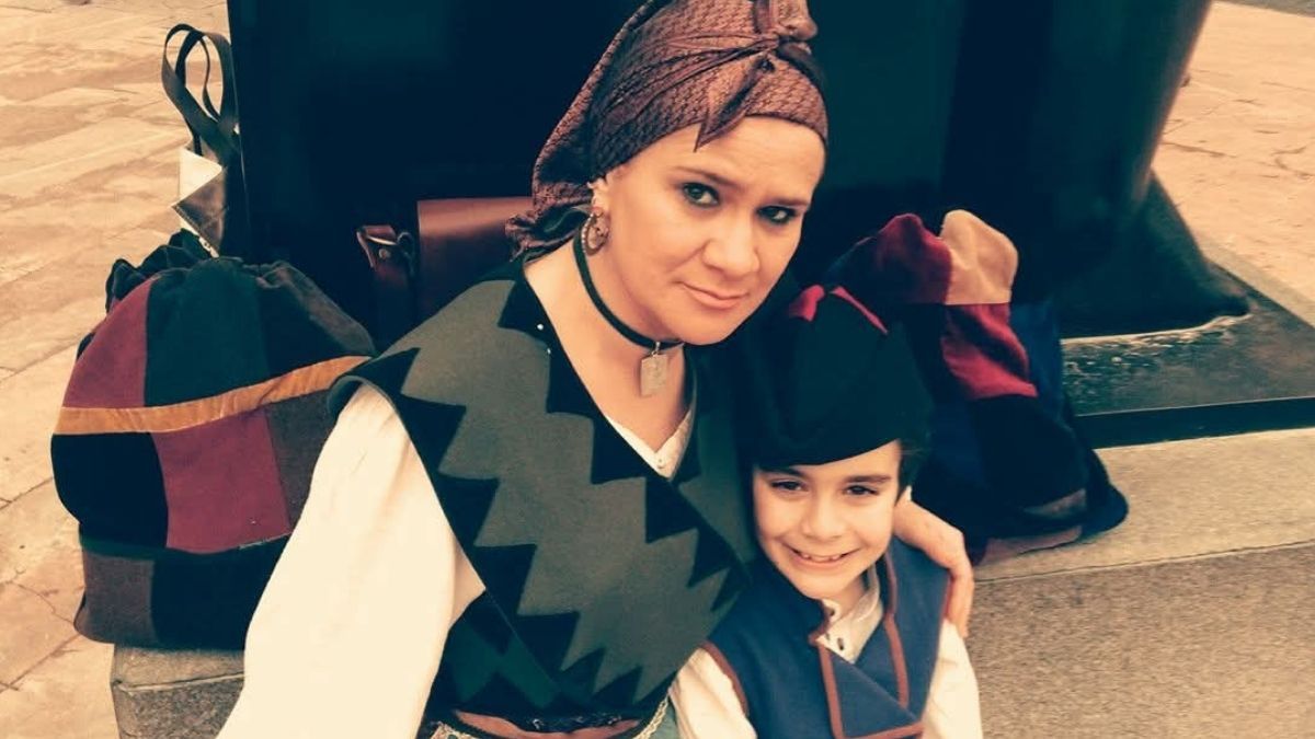 Mujer e hijo luciendo el traje tradicional asturiano con un dengue de paño grueso en tonos verdes, característico de las zonas rurales de montaña y del interior de Asturias para combatir el clima frío.